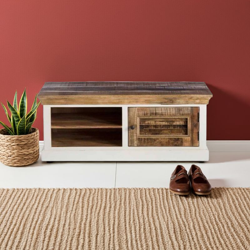 Wooden shoe bench against a red wall with a plant and shoes on a beige rug.