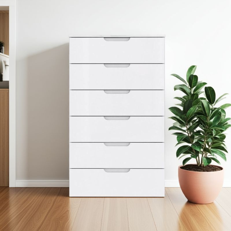 White dresser with multiple drawers next to a potted plant on a wooden floor.