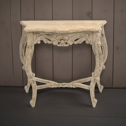 Decorative console table with intricate carvings against a wooden panel background