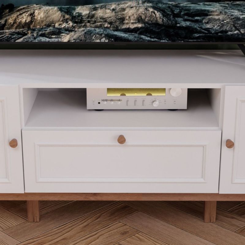 White entertainment console with a television and audio equipment on a wooden floor.