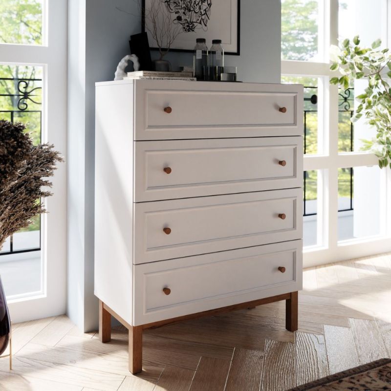 White dresser with wooden legs in a bright room with large windows.