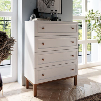 White dresser with wooden legs in a bright room with large windows.