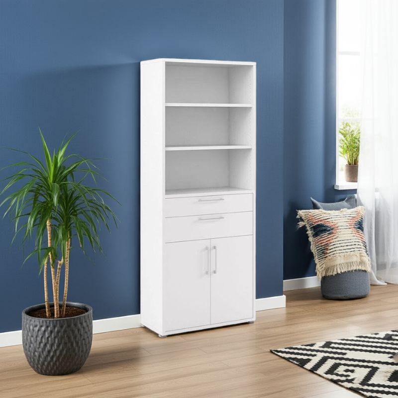 White bookshelf with drawers and cupboard against a blue wall in a room with a plant and rug.