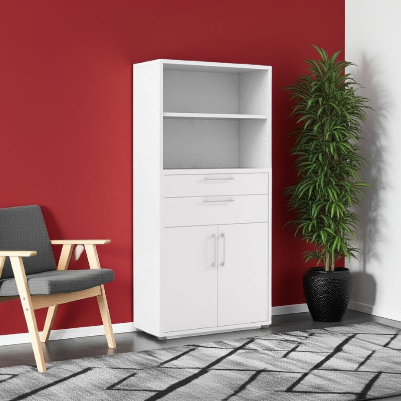 White cabinet with shelves and drawers against a red wall with a gray chair and plant.