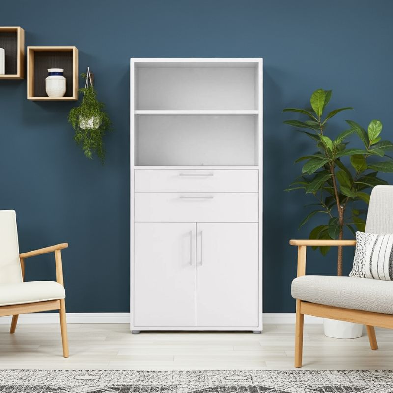White cabinet against a blue wall with two chairs and plants in a room.