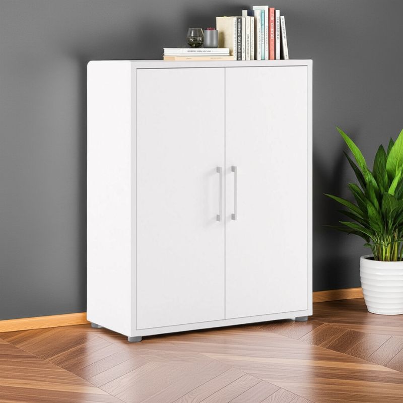 White cabinet with books and a plant on a wooden floor against a gray wall