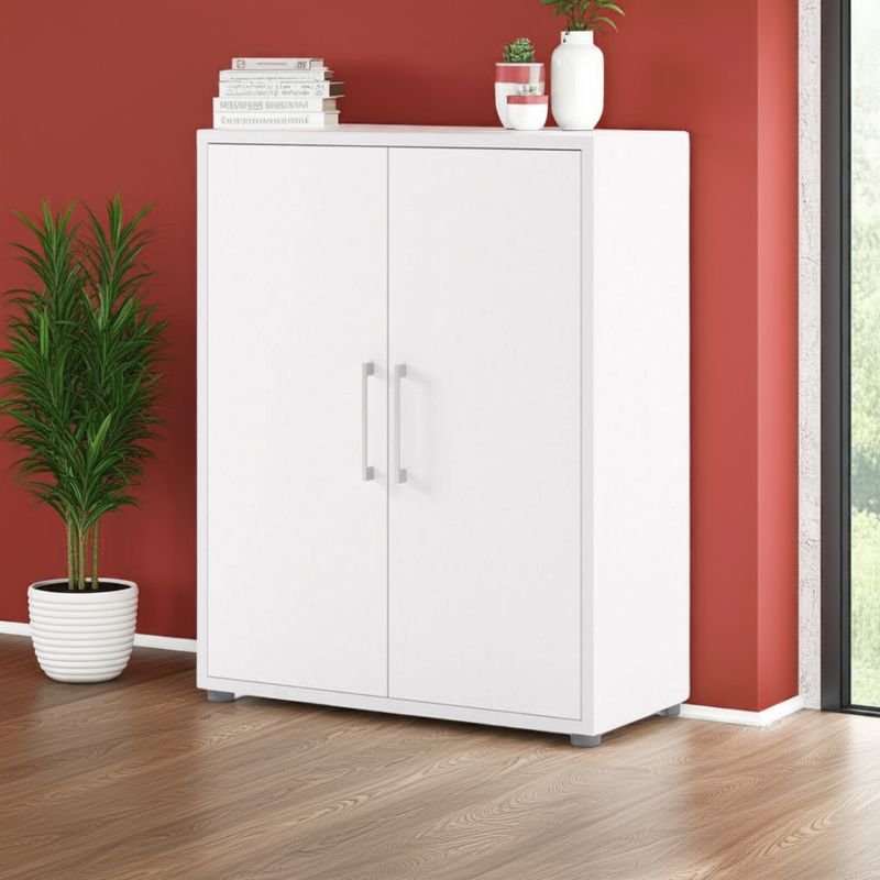 White cabinet with decorative items against a red wall