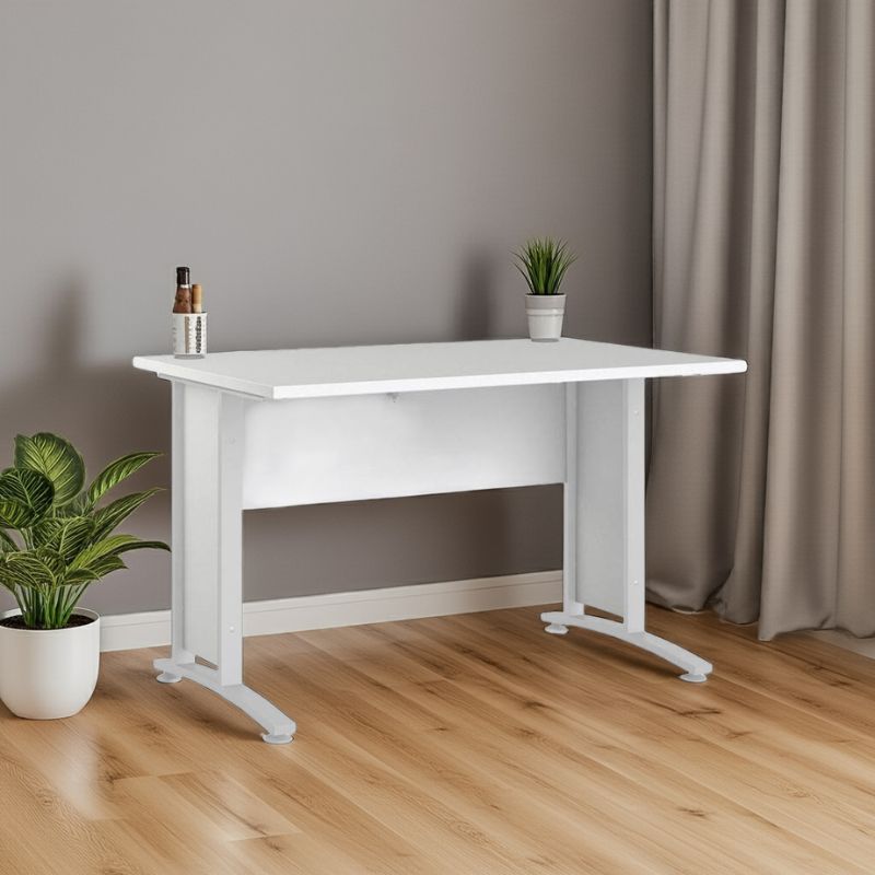 White desk with a plant and small items on a wooden floor against a gray wall.