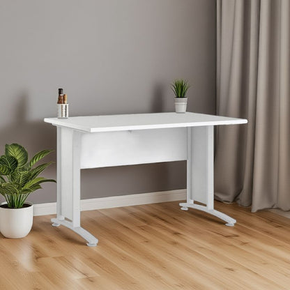 White desk with a plant and small items on a wooden floor against a gray wall.